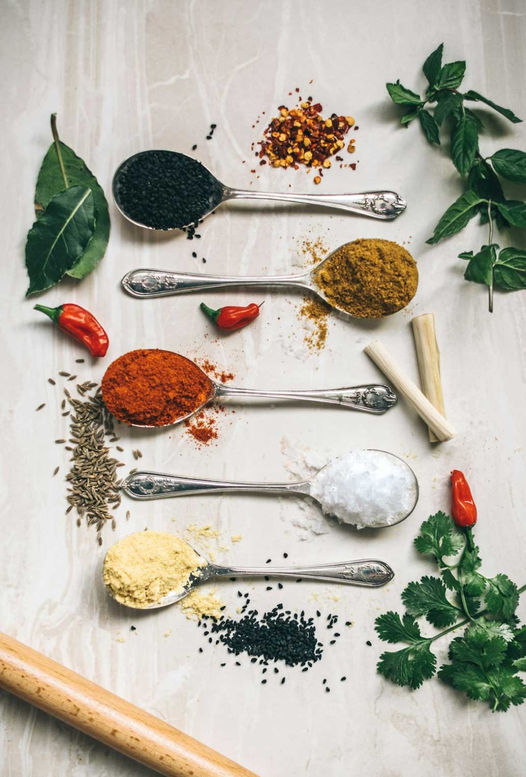 Five spoons filled with various spices used in our Mediterranean spice blends.