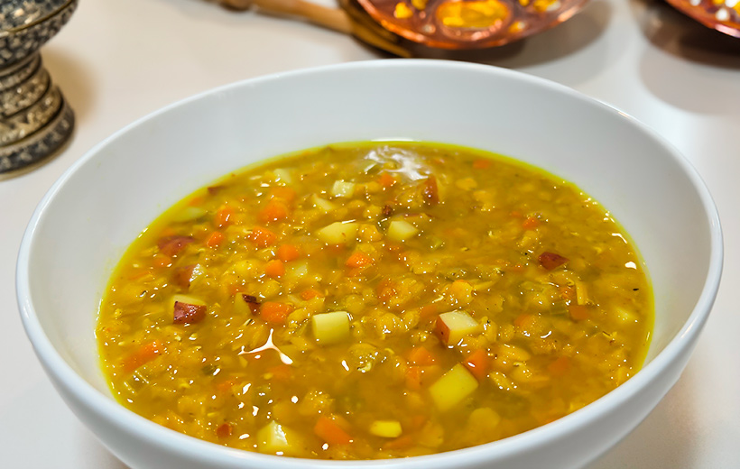 A bowl with Yemeni red lentil soup with "Souper spice" spice blend. Next to it other middle-eastern table ornaments.