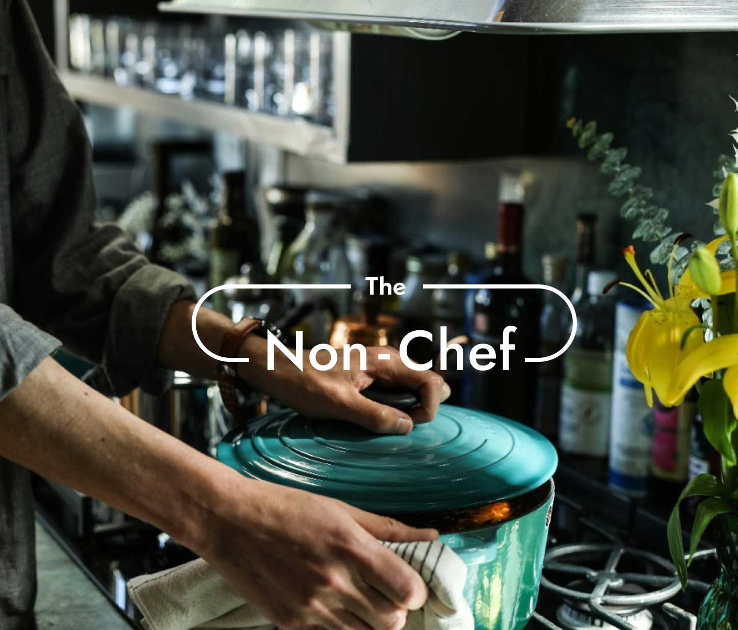 Hands of a cook holding a beautiful light blue cast iron pot on the stove. Behind are various bottles of wine and sauces. on it the title "The non-chef"